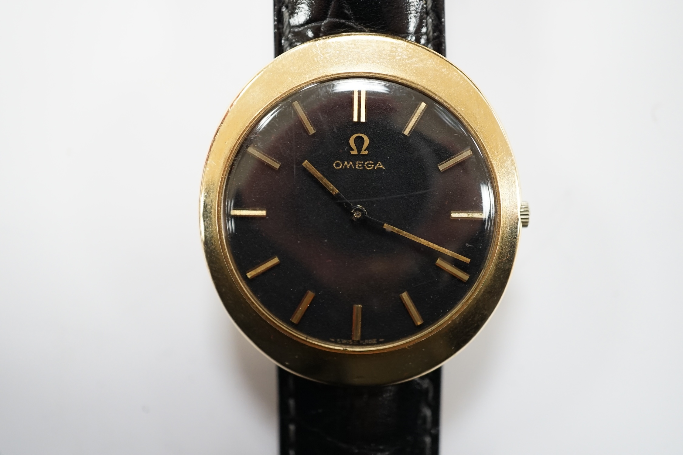 A gentleman's 9ct gold black dial manual wind wrist watch, with Omega box.